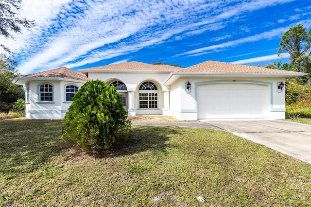 mediterranean / spanish-style house featuring a garage and a front lawn