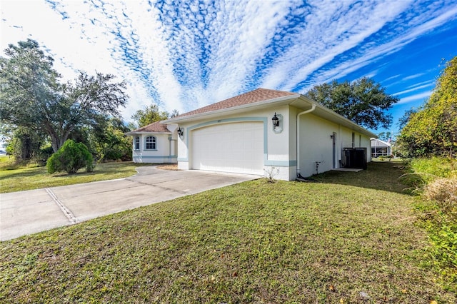 view of front of house with a garage, central AC, and a front lawn