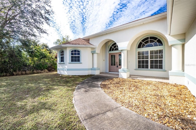 doorway to property featuring a lawn