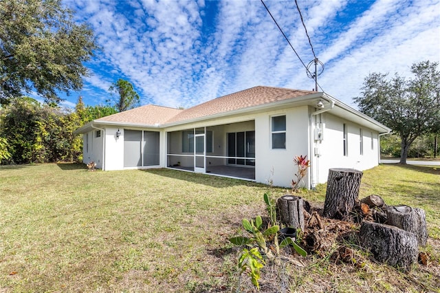 rear view of house with a yard and a sunroom