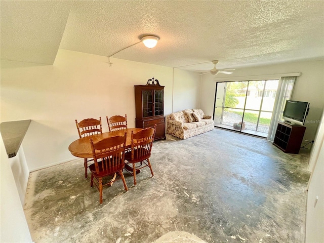 dining area featuring ceiling fan, concrete floors, and a textured ceiling