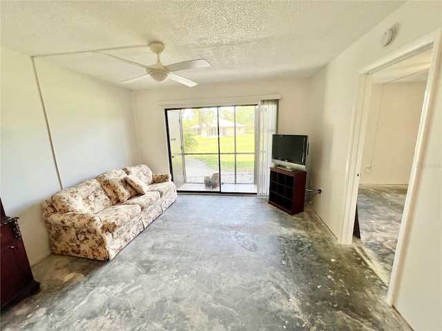 living room featuring ceiling fan and a textured ceiling