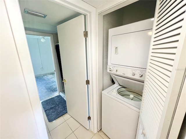 clothes washing area featuring stacked washer / dryer and light tile patterned floors