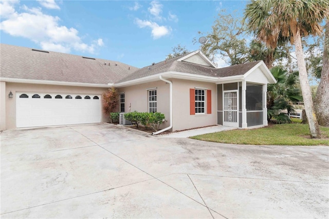 view of front of home featuring a front yard, a garage, and a sunroom