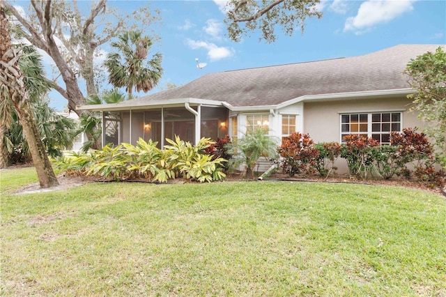 view of front of property with a front yard and a sunroom