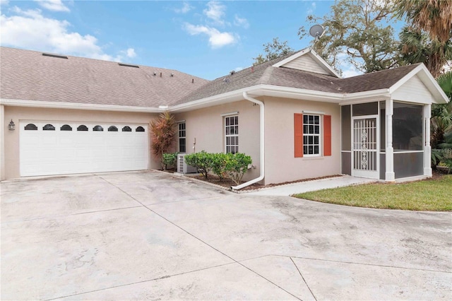 single story home with a garage and a sunroom