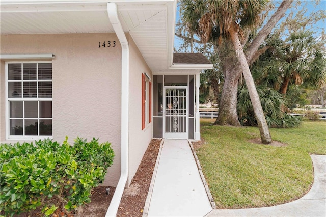 doorway to property with a lawn