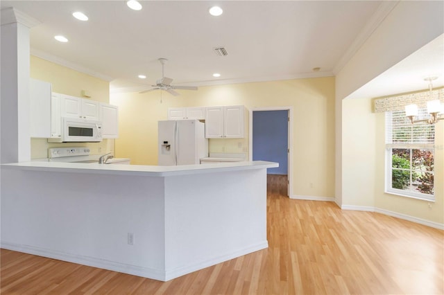 kitchen featuring white cabinetry, kitchen peninsula, white appliances, pendant lighting, and crown molding