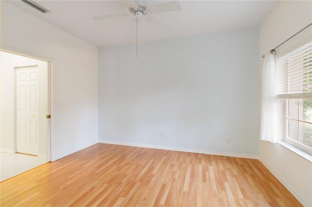 empty room with ceiling fan and light hardwood / wood-style flooring