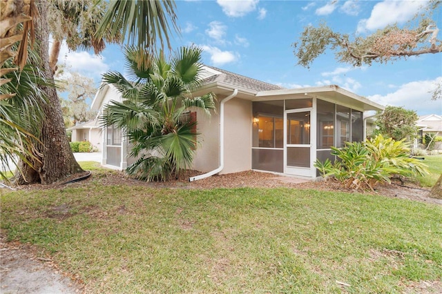 back of house with a sunroom and a yard