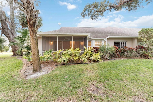 view of front of home with a front yard, ceiling fan, and a sunroom