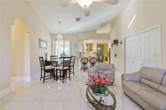 tiled living room with ceiling fan and vaulted ceiling