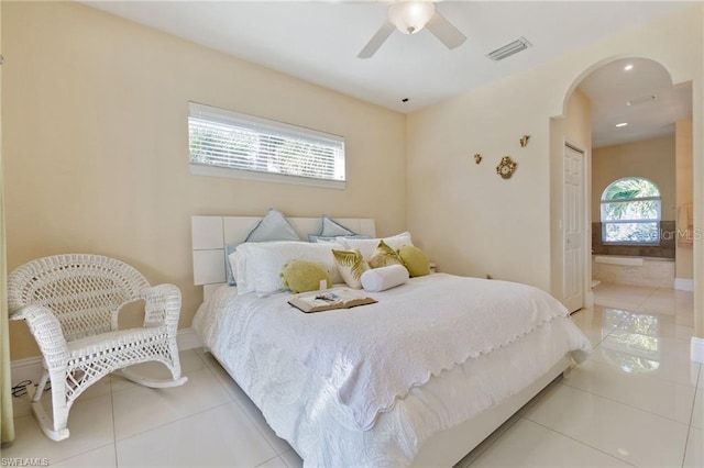 tiled bedroom with ceiling fan and connected bathroom