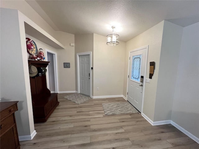 entryway with a textured ceiling and light wood-type flooring