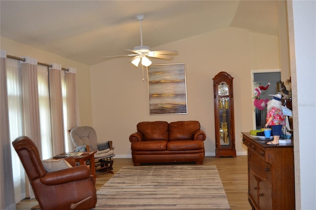 living room with ceiling fan, lofted ceiling, and light hardwood / wood-style flooring