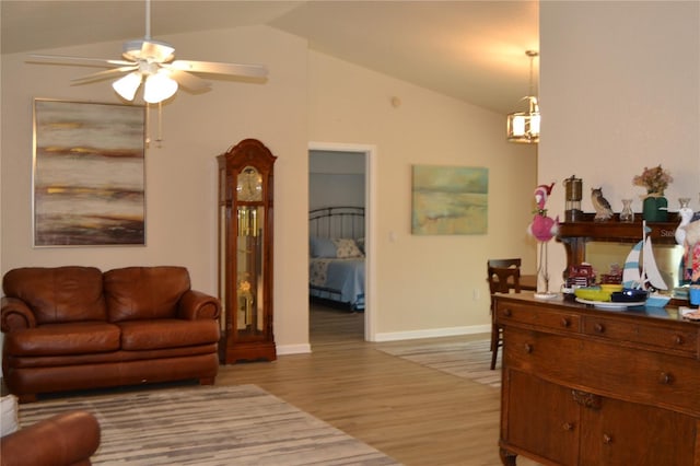 living room with light hardwood / wood-style flooring, ceiling fan, and vaulted ceiling