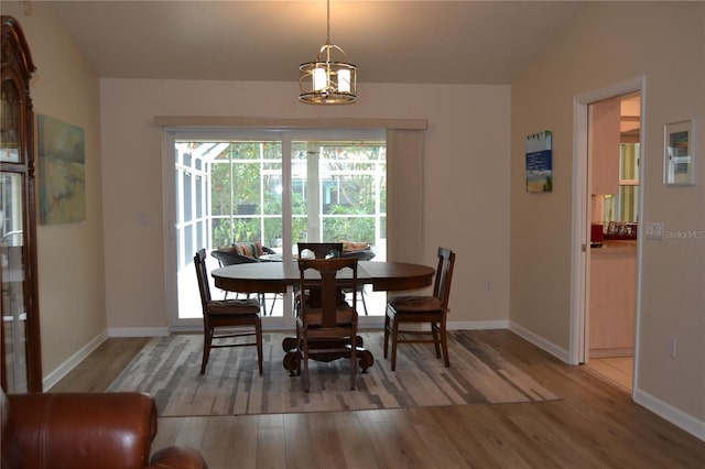 dining space with lofted ceiling and hardwood / wood-style floors