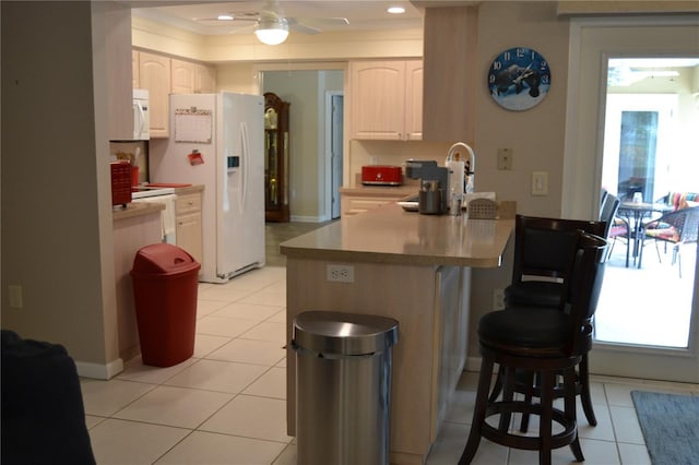 kitchen featuring light tile patterned flooring, a kitchen breakfast bar, ornamental molding, kitchen peninsula, and white appliances