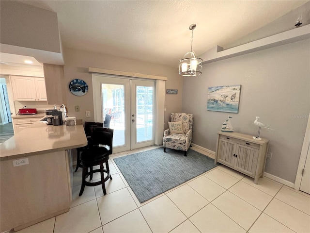 dining area featuring french doors, light tile patterned flooring, and vaulted ceiling