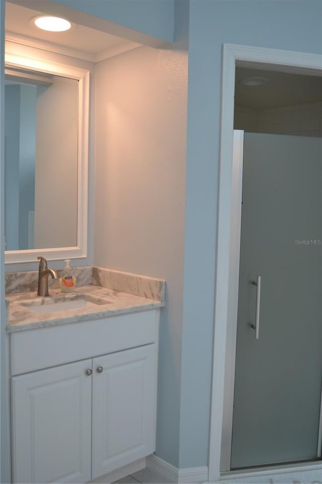 bathroom with vanity and a shower with door