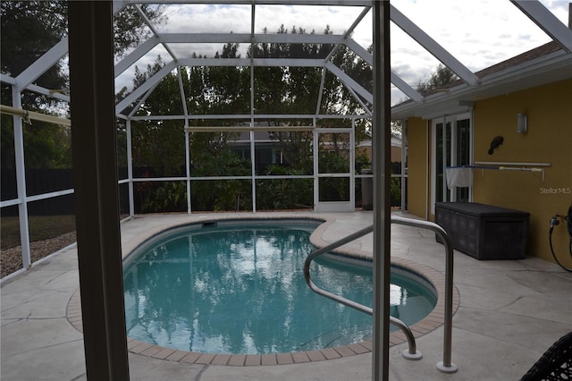 view of swimming pool featuring a lanai and a patio