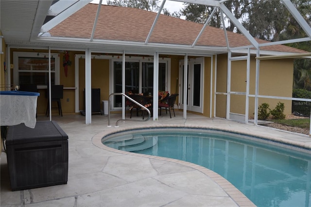 view of swimming pool with a patio, a lanai, and ceiling fan