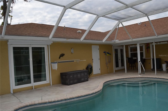 view of swimming pool with a patio, a lanai, and french doors