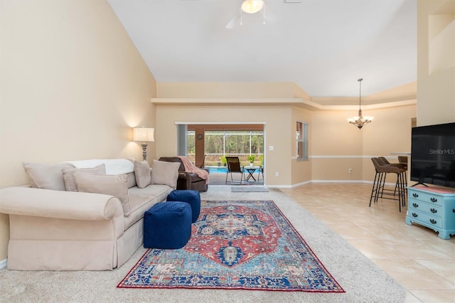 tiled living room featuring ceiling fan with notable chandelier and lofted ceiling