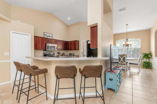 kitchen featuring decorative light fixtures, kitchen peninsula, a breakfast bar area, stainless steel appliances, and a chandelier