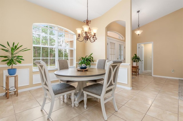 dining space with light tile patterned floors and an inviting chandelier