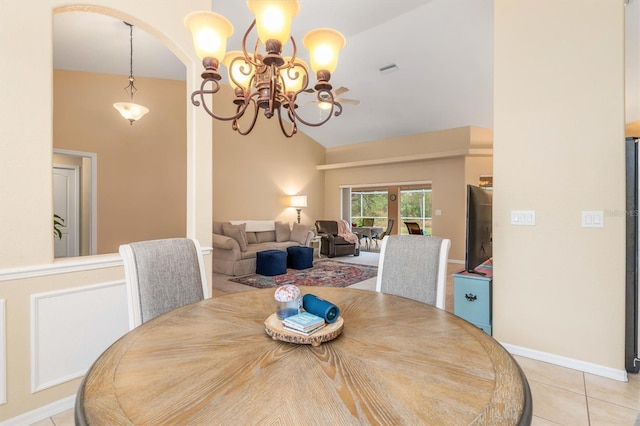 tiled dining room with lofted ceiling and an inviting chandelier