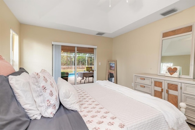 bedroom featuring access to outside, ceiling fan, and a raised ceiling