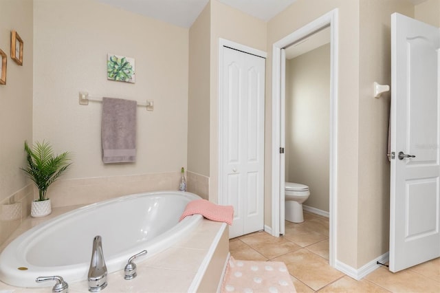 bathroom featuring toilet, tile patterned flooring, and tiled tub