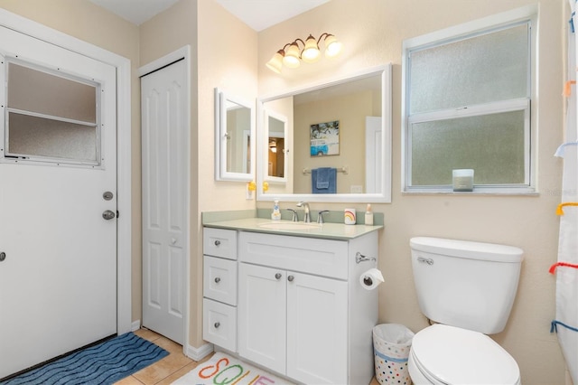 bathroom featuring toilet, vanity, and tile patterned flooring