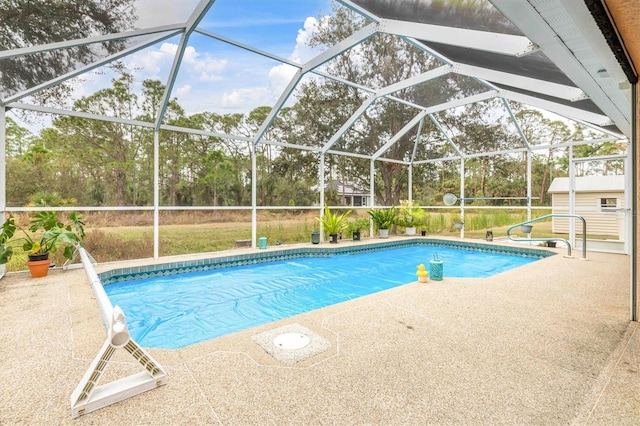 view of swimming pool featuring glass enclosure, a shed, and a patio