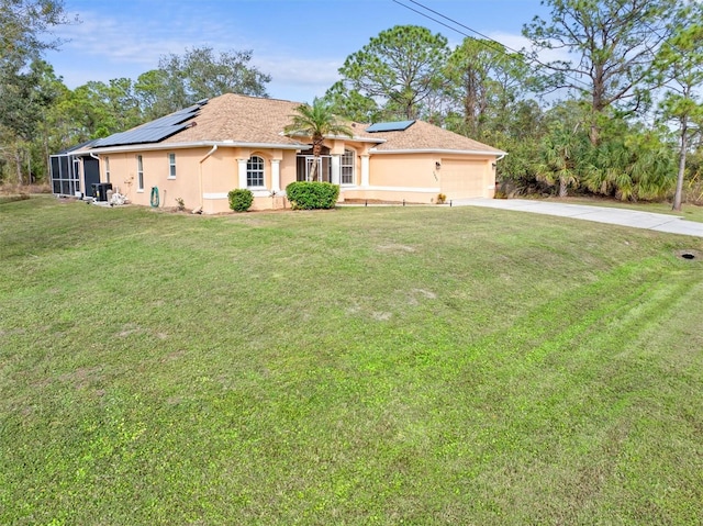 view of front of home with a garage, a front yard, and solar panels