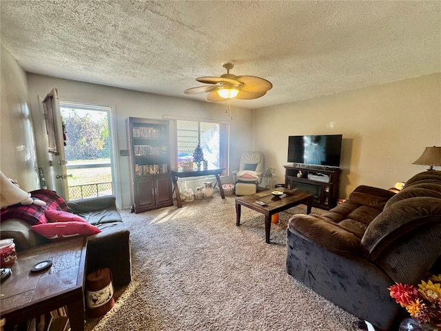 carpeted living room with a textured ceiling and ceiling fan