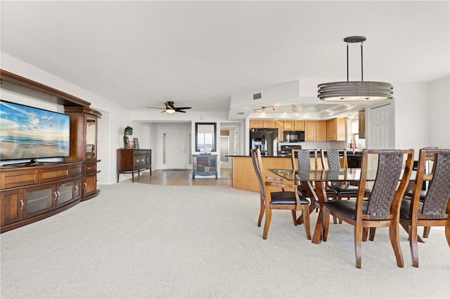 carpeted dining area with sink and ceiling fan