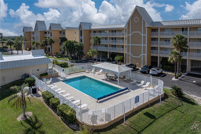 view of pool with central air condition unit, a patio area, and a lawn