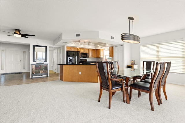 dining area featuring ceiling fan and light carpet