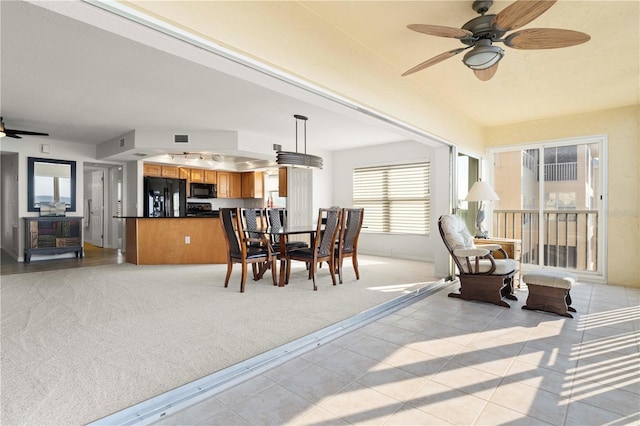 carpeted dining space with ceiling fan