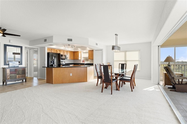 dining area featuring light colored carpet and ceiling fan