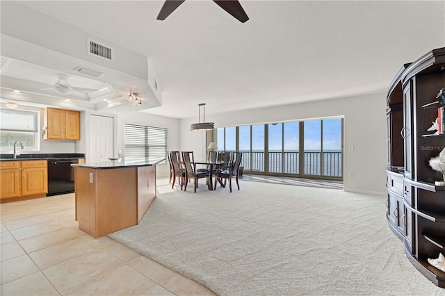 kitchen featuring dishwasher, pendant lighting, a kitchen island, light colored carpet, and sink