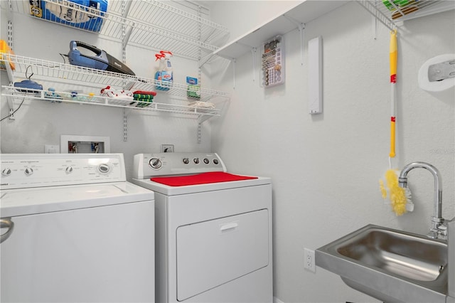 clothes washing area featuring sink and washing machine and clothes dryer