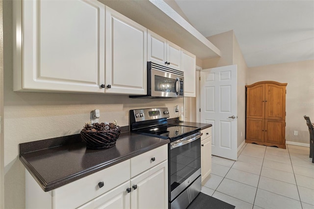 kitchen with white cabinets, light tile patterned floors, and appliances with stainless steel finishes