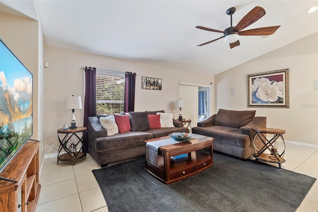 living room with ceiling fan, vaulted ceiling, and light tile patterned floors