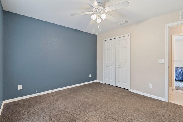 unfurnished bedroom featuring carpet floors, ceiling fan, and a closet