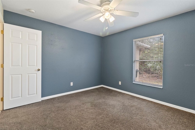 carpeted spare room with ceiling fan