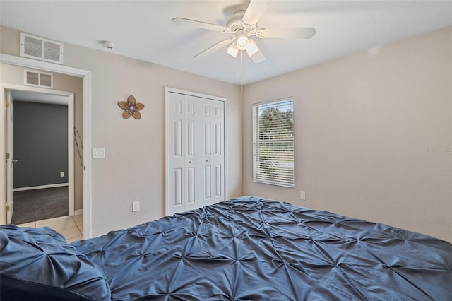 tiled bedroom featuring ceiling fan and a closet