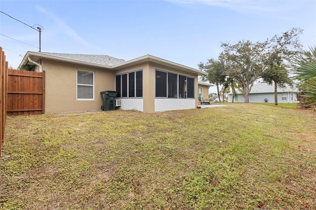 back of property with a yard and a sunroom